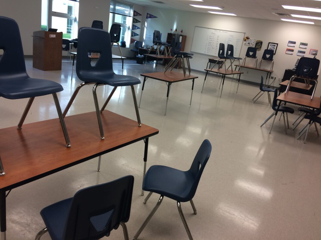 Empty, well-lit classroom with chairs on top of tables